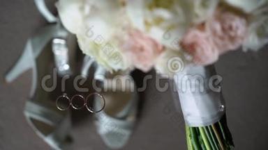 <strong>结婚戒</strong>指，花束和新娘鞋。 婚姻象征的配对。 对新郎新娘的爱